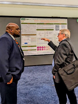 Brandon Gaines, FAMU Senior, engages with judge regarding the effect of different drugs on lung cancer cells.