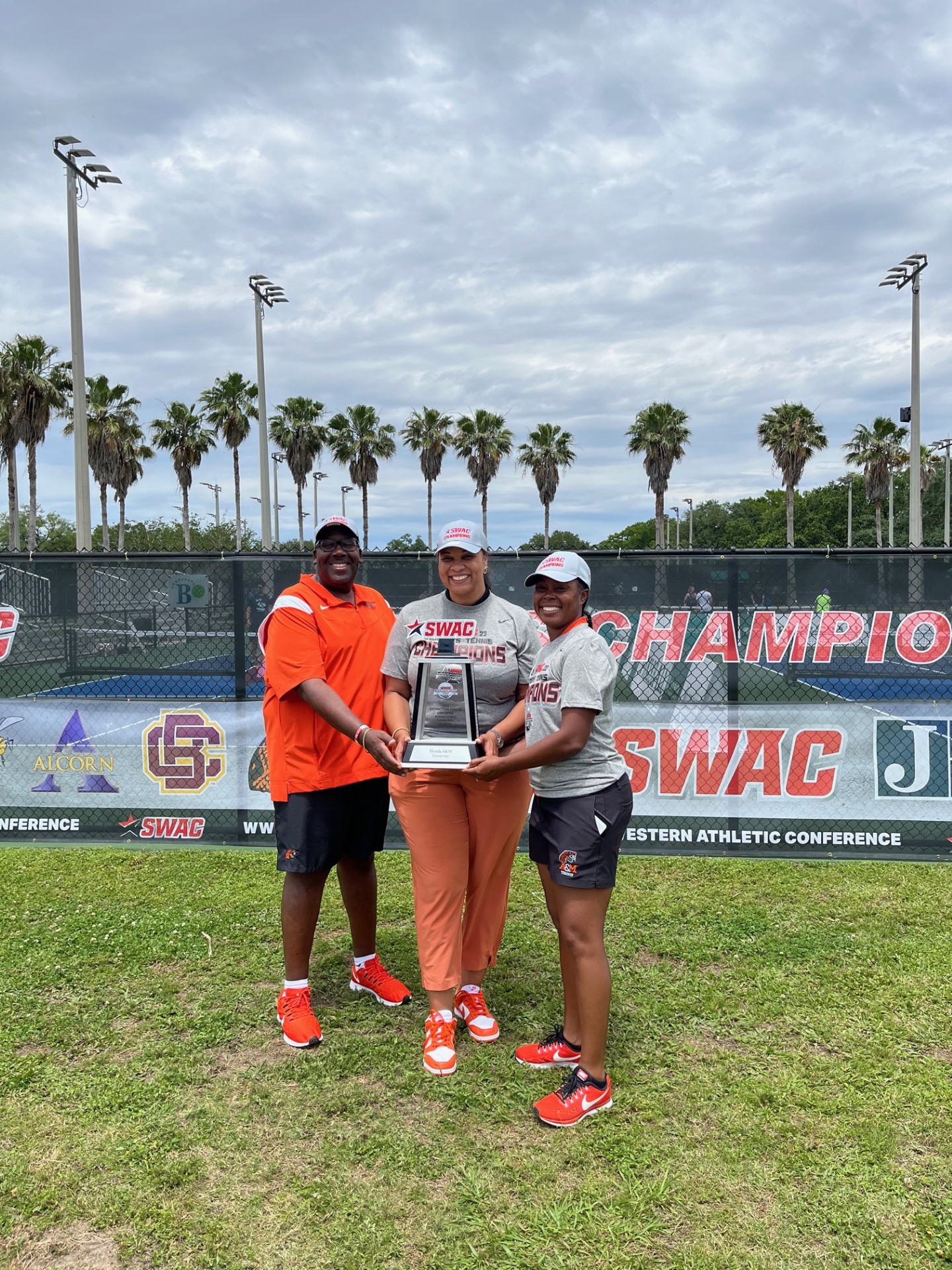 FAMU Tennis Coaches and Athletic Director holding the SWAC Women’s Tennis Tournament Trophy